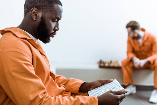 side view of african american prisoner reading book side view of african american prisoner reading book prisoner photos stock pictures, royalty-free photos & images