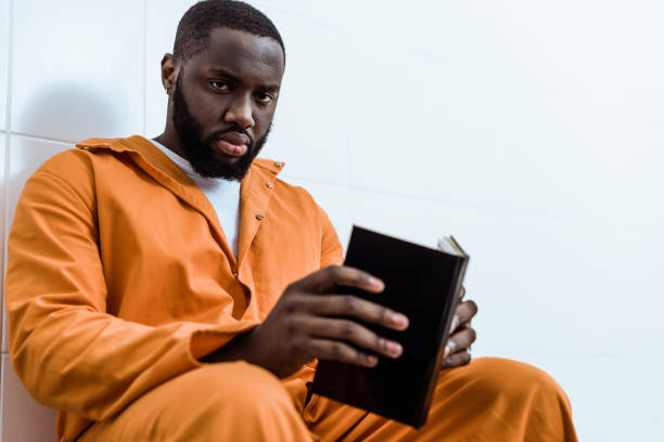 istock african american prisoner holding book and looking at camera 951889124