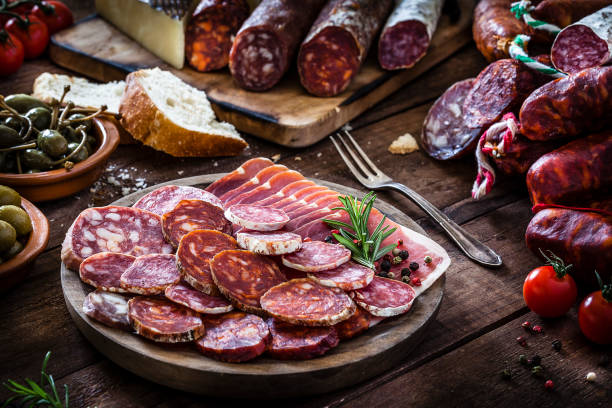 素朴な木製のテーブルの混合スペインのチョリソ スライス プレート - salami ストックフォトと画像