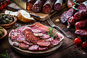 Mixed spanish chorizo slices plate on rustic wooden table
