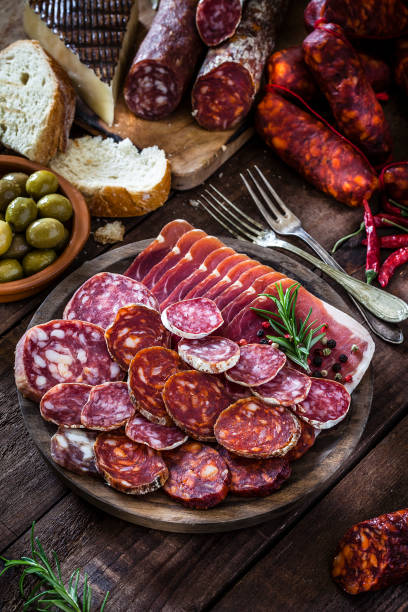 istock Mixed spanish chorizo slices plate on rustic wooden table 951889998