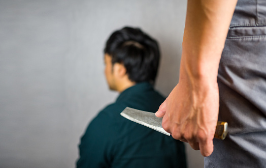 Knife hand hold with man sitting, backstabbing