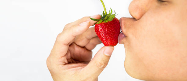 istock Man kissing strawberry and hand holding, white background 951890928