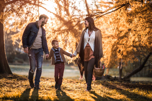 istock Smiling family communicating while walking through autumn park. 951901136