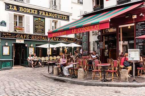 Paris, France - July 06, 2017: The charming restaurant Le Consulat on the Montmartre hill. Parisians and tourists enjoy food and drinks. Montmartre with traditional French cafes and art galleries is one of the most visited landmarks in Paris.