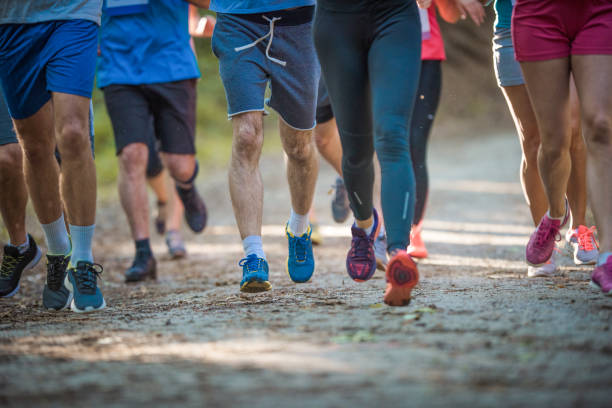 istock Large group of unrecognizable athletes running marathon a in nature. 951907396