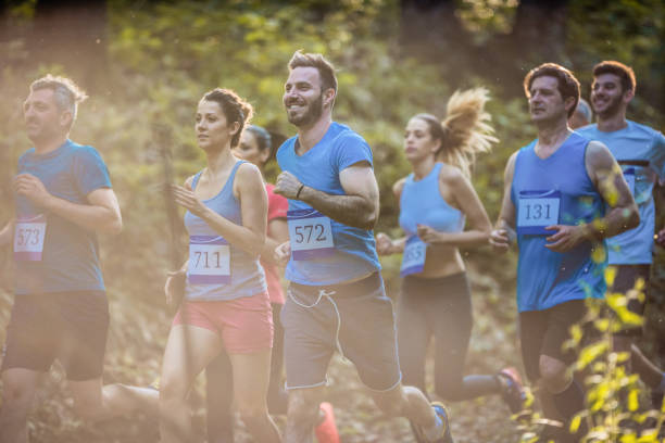 istock Athletic people running a marathon race through the forest. 951907484