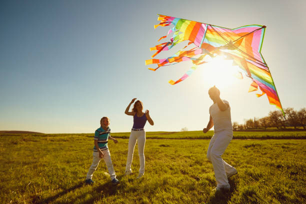 istock Happy family playing with a kite on nature in spring, summer 951914110