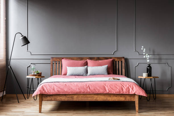 istock A king-size bed standing in a bedroom interior between the bedside tables and with a black lamp next to it 951914438
