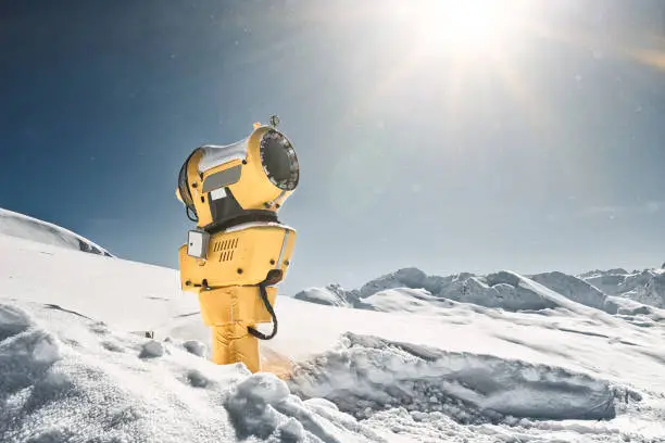 Photo of yellow snow machine cannon in beautiful winter landscape on Jakobshorn, Switzerland