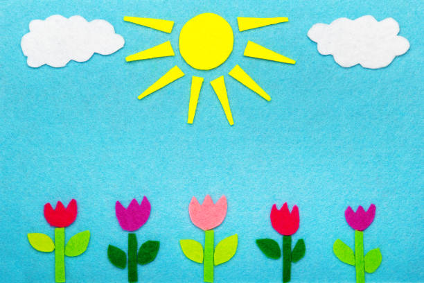 istock Colorful felt background with sun, clouds and tulip flowers, copy space 951927286