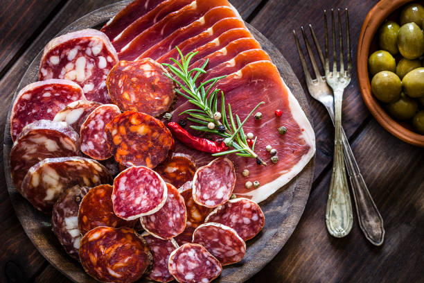 istock Mixed spanish chorizo slices plate shot from above on rustic wooden table 951927368