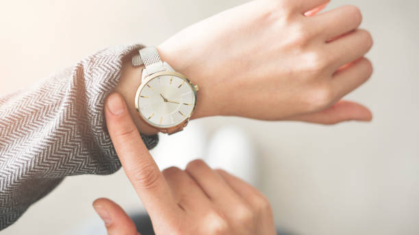 女性チェック タイム彼女の腕時計 - 時計 ストックフォトと画像