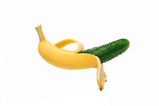istock Green cucumber in a banana peel on a white background, isolate. Genetically modified fruit. Image computer collage. The concept of GMF. Not what it seems, a deception, a paradox. 951929930