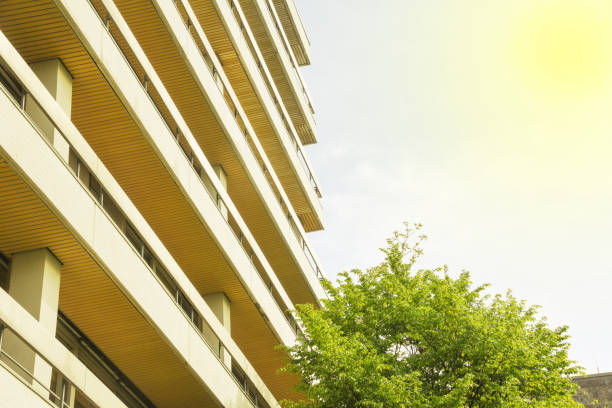 istock Balconies at a skyscraper with a tree in front of blue sky in the sunlight 951941800