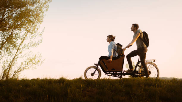 Couple of adventurers in cargo bike ride Couple of adventurers in cargo bike ride cargo bike photos stock pictures, royalty-free photos & images