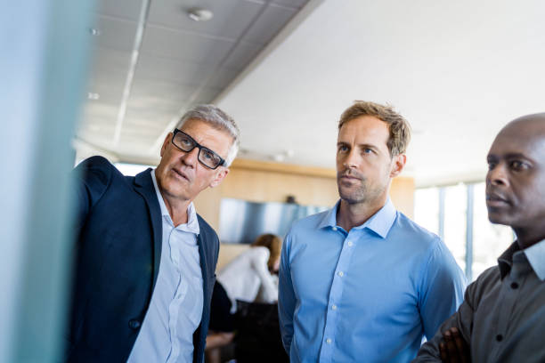 istock Confident businessman explaining to male coworkers 951945782