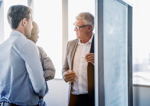 istock Mature businessman discussing with colleagues 951946816