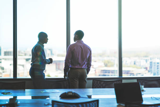 istock Businessmen discussing by window in office 951951484