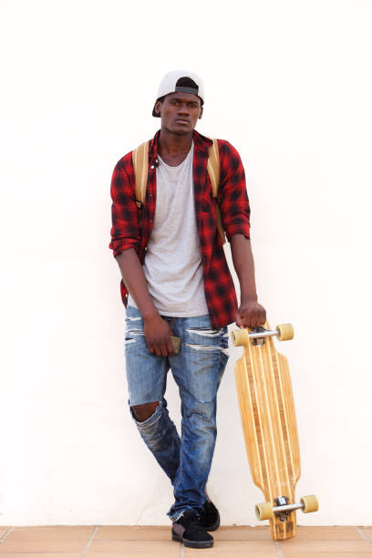 istock Young African American student leaning against wall with skateboard 951961212
