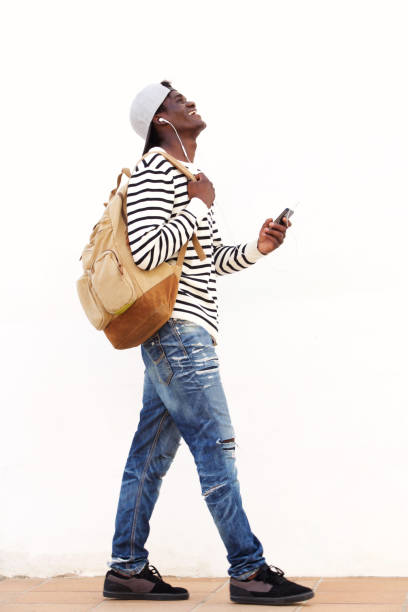 istock laughing young guy walking with bag and phone 951961260