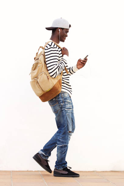 istock Full length African American student walking with smart phone 951961268