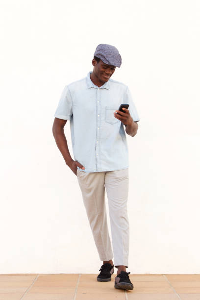 istock Full length handsome african man reading text message on his mobile phone 951961298