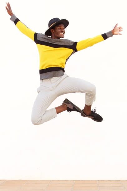 istock happy young african man jumping in air over white background 951962148