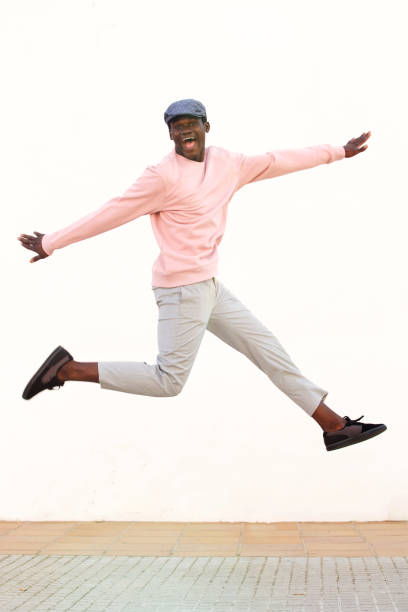istock Excited young african man jumping with joy against white wall 951962830