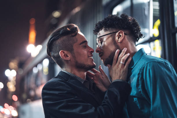 schwule jungs küssen nach der arbeit in der nacht - küssen stock-fotos und bilder