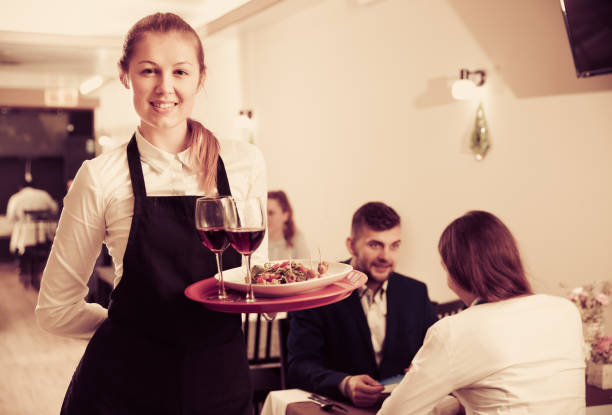 istock Affable female waiter is standing with order in luxury restaurante 951978072