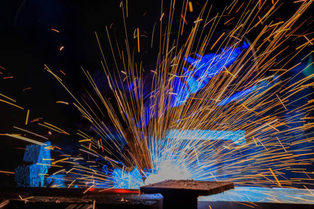 istock Worker is welding metal part in factory 951978686