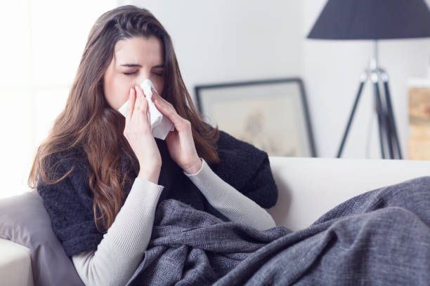 istock Woman sneezing nose with tissue 951983456