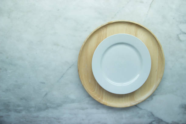 istock Top view, Closed up empty blank dishware on wooden tray and place on grey granite table. 951993508