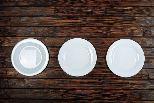 istock Plates, Three plates, empty plates, white plates, wooden backgrond 951997524