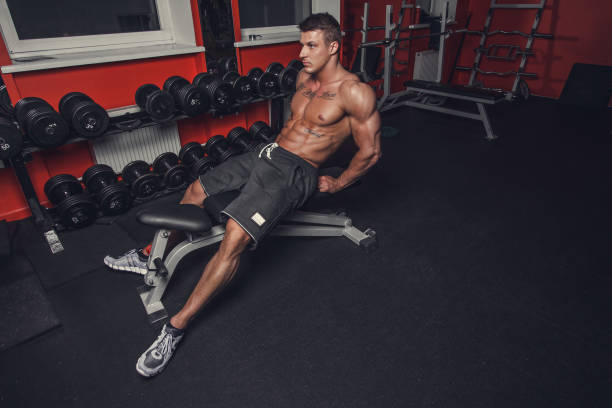 a man relaxing in a gym club. - muscular build men tattoo human arm imagens e fotografias de stock