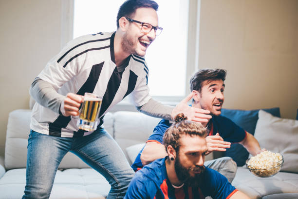 istock Male football supporters cheering for different teams 951999180