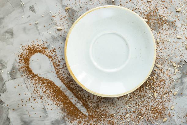 istock Empty blue small plate next to a spoonful of cocoa on a gray background. Copyspace 951999926