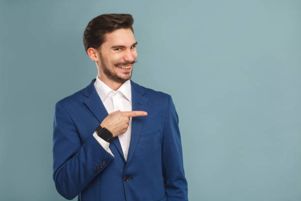 istock Happiness man pointing finger at copy space and toothy smiling 952000414