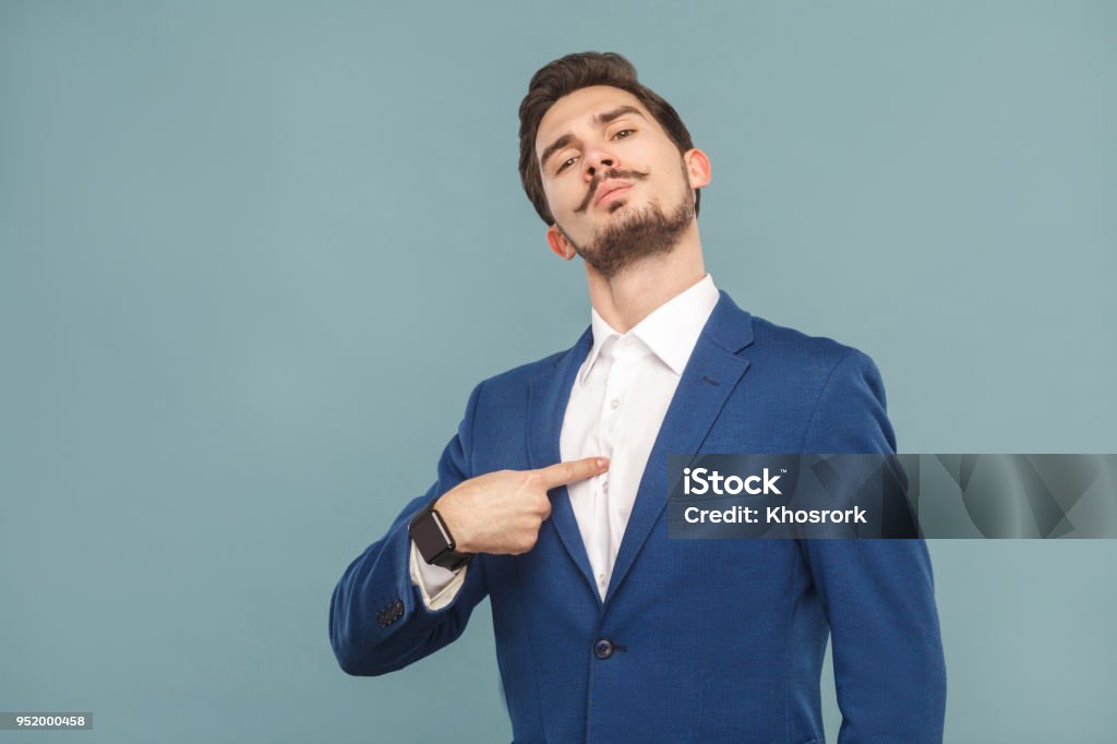 Closeup portrait of proud man pointing finger himself Closeup portrait of proud man pointing finger himself. Business people concept, richly and success. Indoor, studio shot on light blue background Showing Off Stock Photo