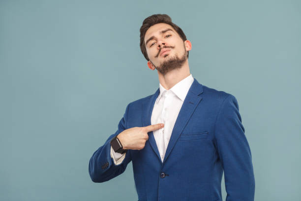 Closeup portrait of proud man pointing finger himself Closeup portrait of proud man pointing finger himself. Business people concept, richly and success. Indoor, studio shot on light blue background showing off stock pictures, royalty-free photos & images