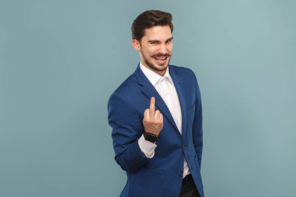 istock Cunning businessman showing the middle finger at camera and smiling 952000484
