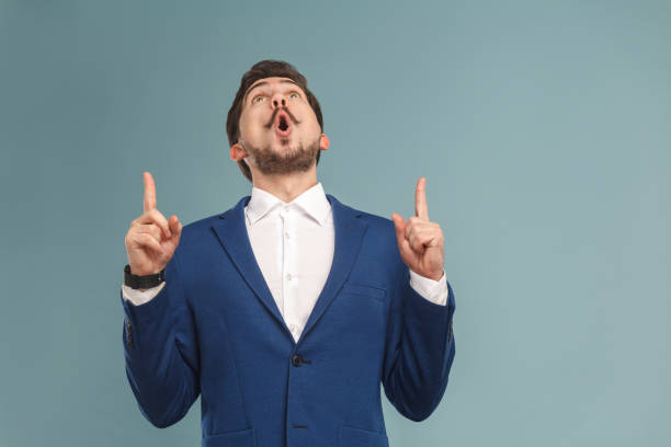 istock Wondered man pointing finger and look up at copy space 952000534
