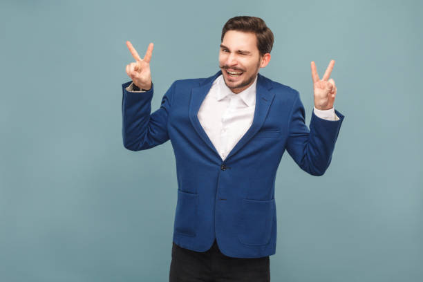 istock Peace. Business man wink and showing v sign 952000584