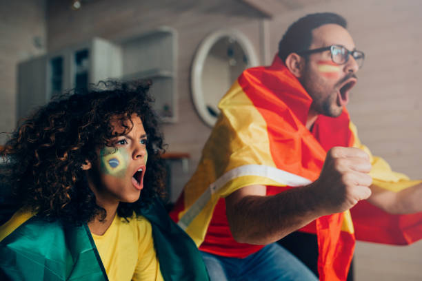 istock Couple shouting while watching soccer game on TV 952002326