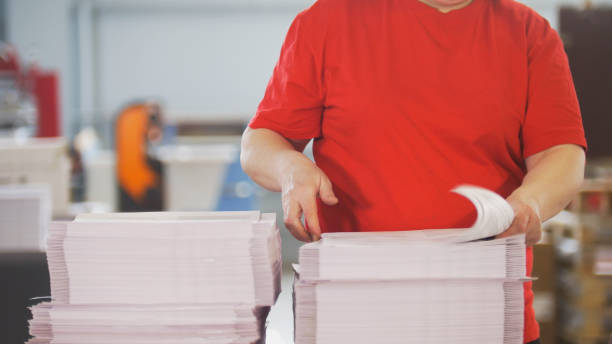 istock Female worker typography turning pages of a printed magazine 952005172