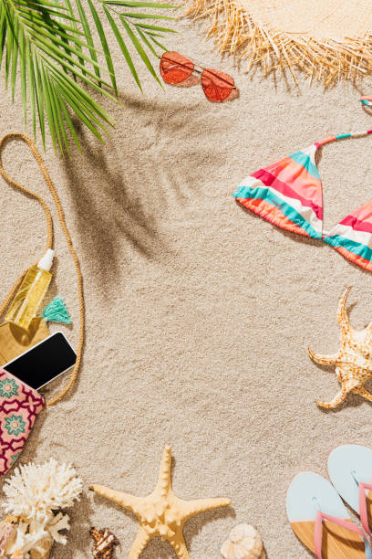istock top view of female accessories lying on sandy beach 952010768