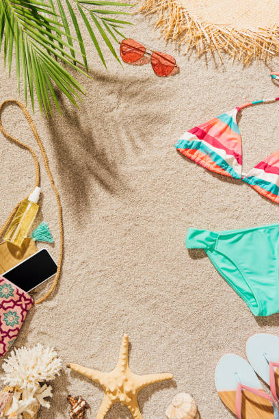 istock top view of bikini and accessories lying on sandy beach 952011532