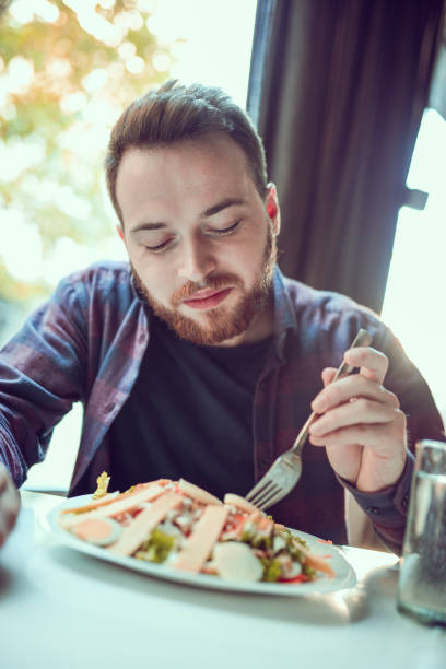 istock Young Smiling Man Eating Fresh Salad in the Morning 952013220