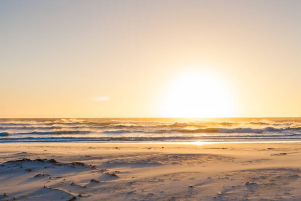 istock Rough waves at sunset on a sandy beach with reflections on the water 952013566